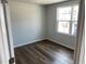 The empty bedroom features gray walls, a window for natural light and hardwood flooring at 4004 Silver Oak Ln, Durham, NC 27703