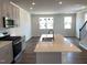 Open kitchen has an island with a sink and stainless steel appliances next to a living area at 4004 Silver Oak Ln, Durham, NC 27703