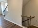 Staircase with hardwood flooring and railings with black iron spindles at 4004 Silver Oak Ln, Durham, NC 27703