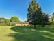 Spacious backyard with ample green space and mature trees surrounding the brick home at 4170 Buckhorn Rd, Sanford, NC 27330