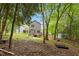 A shady backyard view showcasing a wooden deck with stairs leading to a concrete patio at 419 E East Hinton St, Clayton, NC 27520
