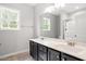 Bright bathroom featuring a double sink vanity with chrome fixtures and a large mirror reflecting the natural light from the window at 419 E East Hinton St, Clayton, NC 27520