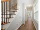Inviting hallway featuring hardwood floors, staircase with iron spindles, and an abundance of natural light at 419 E East Hinton St, Clayton, NC 27520