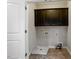 A laundry room with dark brown cabinets, a tile floor, and a white door at 419 E East Hinton St, Clayton, NC 27520