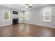Cozy living room featuring hardwood floors, fireplace, ceiling fan and multiple windows at 419 E East Hinton St, Clayton, NC 27520