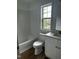 Clean bathroom featuring white subway tile surround, a single sink vanity, and a window at 427 Lakeland St, Durham, NC 27701