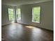 Bright bedroom with hardwood floors featuring three large windows offering natural light at 427 Lakeland St, Durham, NC 27701