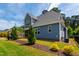 A well manicured backyard with green grass, trees, and a screened-in porch at 4412 Powell Grove Ct, Raleigh, NC 27606
