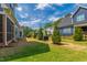 Well maintained backyard with lawn, young trees, grill, and view of other homes at 4412 Powell Grove Ct, Raleigh, NC 27606