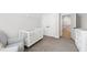 Neutral Bedroom with a white crib and gray armchair near a closet and doorway at 4412 Powell Grove Ct, Raleigh, NC 27606