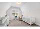 Bright Bedroom with a white crib, cozy armchair, and changing table near a window at 4412 Powell Grove Ct, Raleigh, NC 27606