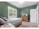 Cozy bedroom with green walls, a full bed, and a shuttered window at 4412 Powell Grove Ct, Raleigh, NC 27606