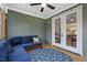 Comfortable covered porch featuring stylish blue lounge furniture, modern ceiling fan and access to both interior and exterior spaces at 4412 Powell Grove Ct, Raleigh, NC 27606