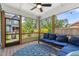 Cozy screened porch with comfortable blue seating, a ceiling fan, and views of the landscaped backyard at 4412 Powell Grove Ct, Raleigh, NC 27606