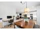 Open dining area showing natural light, contemporary lighting fixture, open design and adjacent kitchen and living spaces at 4412 Powell Grove Ct, Raleigh, NC 27606