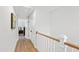 Upstairs hallway with hardwood floors and white walls providing access to several rooms and attic storage at 4412 Powell Grove Ct, Raleigh, NC 27606