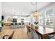 Open concept kitchen and dining area featuring a large wooden dining table, island seating and stylish white cabinetry at 4412 Powell Grove Ct, Raleigh, NC 27606
