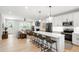 Bright kitchen with white cabinets, stainless appliances, island seating, and open views to a living room with a fireplace at 4412 Powell Grove Ct, Raleigh, NC 27606