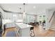 Bright, open kitchen with white cabinetry, stainless steel appliances, and an island with seating, plus open access to dining area at 4412 Powell Grove Ct, Raleigh, NC 27606