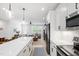 Modern kitchen featuring white cabinets, stainless steel appliances, and an open floor plan to a comfortable living space at 4412 Powell Grove Ct, Raleigh, NC 27606