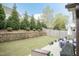 Well-maintained backyard features a retaining wall, mature trees, and a cozy patio with seating area at 45 Davelyn Ct, Garner, NC 27529