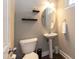Well-lit half bath with a pedestal sink, decorative shelves, and modern fixtures at 45 Davelyn Ct, Garner, NC 27529