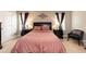 Elegant bedroom featuring a soft pink bedspread, dark furniture, and natural light at 45 Davelyn Ct, Garner, NC 27529