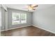 A bright bedroom with dark wood floors, light grey walls and a ceiling fan fixture at 5000 Avenida Del Sol Dr, Raleigh, NC 27616