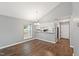 Open dining area with hardwood floors, a modern chandelier, and bright natural light from the window at 5000 Avenida Del Sol Dr, Raleigh, NC 27616