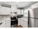 Bright kitchen boasts stainless steel appliances, white cabinets, and marble-style countertops, enhanced by natural light at 5000 Avenida Del Sol Dr, Raleigh, NC 27616