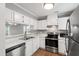 Well-lit kitchen featuring stainless steel appliances, white cabinetry, and elegant countertops for a modern look at 5000 Avenida Del Sol Dr, Raleigh, NC 27616