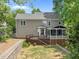 An expansive backyard featuring a wooden deck, screened porch, and landscaped retaining wall at 504 Cameron Glen Dr, Apex, NC 27502