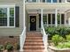 A lovely front entrance with brick steps, a wreath, and a covered porch at 504 Cameron Glen Dr, Apex, NC 27502