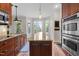 Open kitchen with a central island with granite countertop, stainless steel appliances, and a sink with black faucet at 504 Cameron Glen Dr, Apex, NC 27502