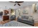 Comfortable living room with a ceiling fan, wood flooring, and a view to the open kitchen and stairway at 504 Cameron Glen Dr, Apex, NC 27502