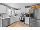 Bright kitchen with white cabinets, stainless steel appliances, and white tile backsplash at 508 2Nd Street St, Apex, NC 27502
