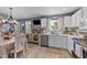 Kitchen with white cabinetry, stainless steel appliances, and an adjacent dining area with a television at 508 2Nd Street St, Apex, NC 27502