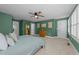 This bedroom has a ceiling fan, large window, and sage green walls at 511 N Person St # 101, Raleigh, NC 27604