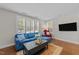 Bright living room with hardwood floors, large windows, and a comfortable blue sofa at 511 N Person St # 101, Raleigh, NC 27604