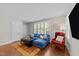 Bright living room featuring a blue sectional sofa, hardwood floors, and plantation shutters at 511 N Person St # 101, Raleigh, NC 27604