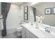 A well-lit bathroom features a double sink vanity, full-size mirror, and a shower-tub combination with a decorative shower curtain at 533 Freedom Trail Dr, Willow Springs, NC 27592