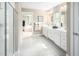 Bathroom featuring dual vanities, white cabinetry, a glass-enclosed shower, and an ensuite to the main bedroom at 533 Freedom Trail Dr, Willow Springs, NC 27592