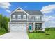 Charming two-story home with gray siding, stone accents, and a welcoming front porch at 533 Freedom Trail Dr, Willow Springs, NC 27592