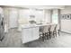 Bright kitchen featuring an island with bar seating, white cabinets, and stainless steel appliances at 533 Freedom Trail Dr, Willow Springs, NC 27592