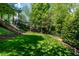 Manicured lawn in the backyard with garden beds and mature trees at 5605 Cary Glen Blvd, Cary, NC 27519