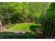 Lush backyard with manicured lawn and mature trees providing shade and privacy at 5605 Cary Glen Blvd, Cary, NC 27519