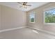 Bedroom with carpet floors, ceiling fan, and view of the outdoors through windows at 5605 Cary Glen Blvd, Cary, NC 27519
