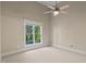 Bright bedroom featuring a ceiling fan, neutral walls, and a window with a view of the outdoors at 5605 Cary Glen Blvd, Cary, NC 27519