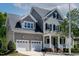 Charming two-story home featuring a two-car garage and inviting front porch with black shutters at 5605 Cary Glen Blvd, Cary, NC 27519
