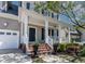 Front porch featuring brick steps, white columns and railings, and a black front door at 5605 Cary Glen Blvd, Cary, NC 27519